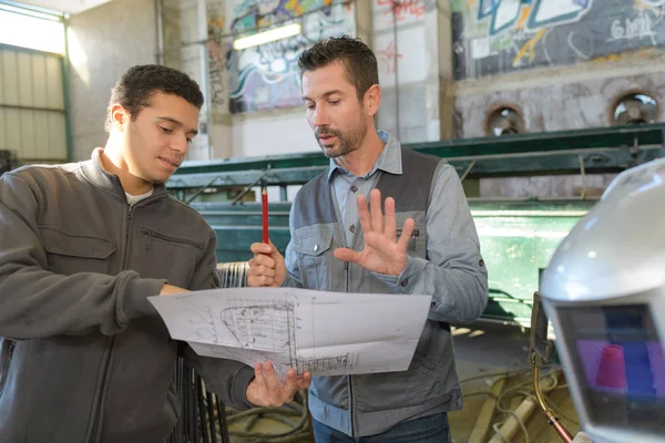 Werken ingenieurs met fabriek plannen — Stockfoto