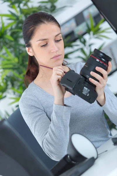 Pretty young woman cleaning dslr camera — Stock Photo, Image