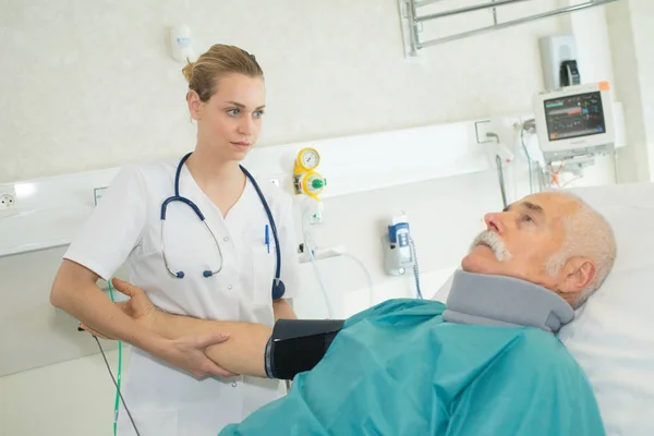 Врач проверяет кровяное давление пациентов — стоковое фото