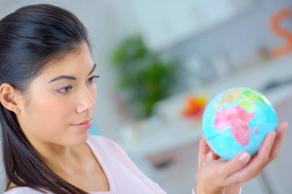 Mulher segurando um globo em miniatura — Fotografia de Stock