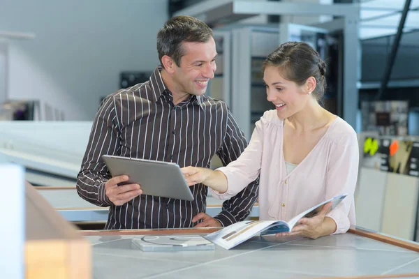 Paar überprüft Broschüre in einem Geschäft — Stockfoto