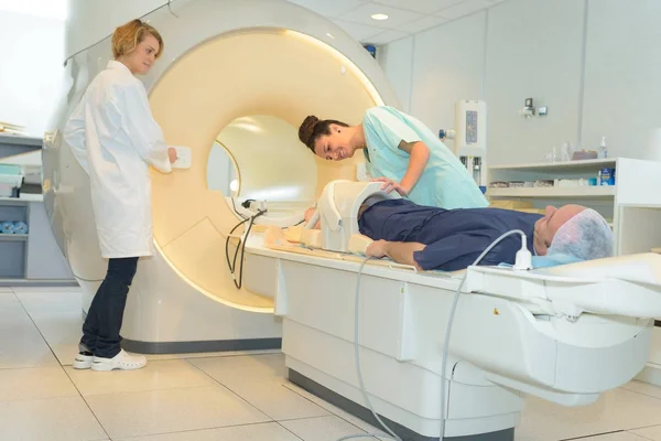 Médico y enfermero preparando al paciente para la resonancia magnética en el hospital — Foto de Stock