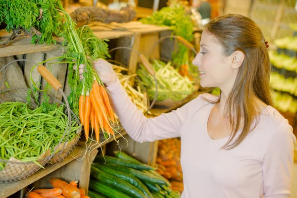 Lady comprando zanahorias frescas —  Fotos de Stock