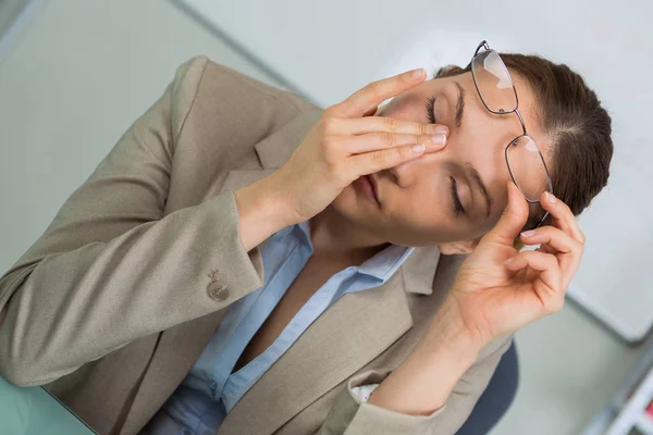 Mujer joven en la oficina cansándose —  Fotos de Stock
