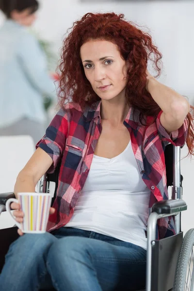 Alegre mujer discapacitada sosteniendo taza de café caliente en casa —  Fotos de Stock