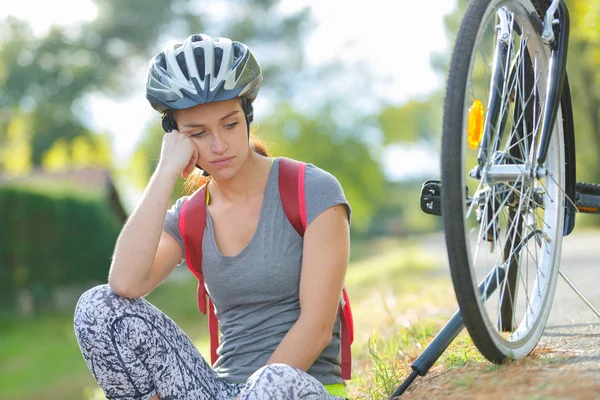 Utmattad tjej om på marken efter cykellopp — Stockfoto