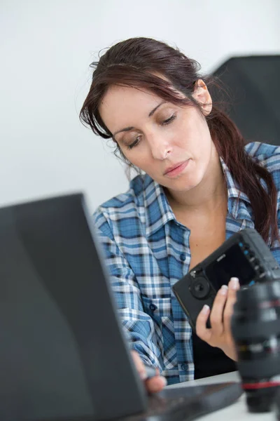 Fotógrafo feminino fazendo algumas pesquisas para corrigir seu equipamento quebrado — Fotografia de Stock