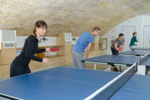 Mooie vrouw spelen ping-pong met vrienden — Stockfoto