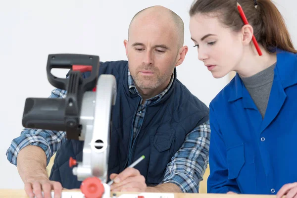 Ung dam lära sig att använda en chopsaw — Stockfoto