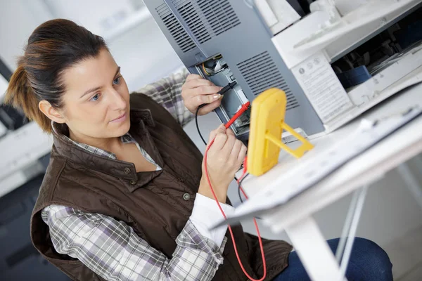 Frau misst die Spannung einer Maschine — Stockfoto