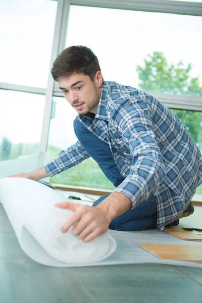 Man isolatie op de vloer te leggen — Stockfoto