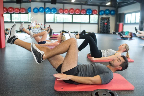 Groupe d'adultes sur le dos faisant des étirements musculaires — Photo