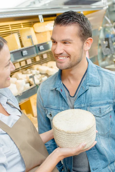 Homem comprando queijo e jovens — Fotografia de Stock