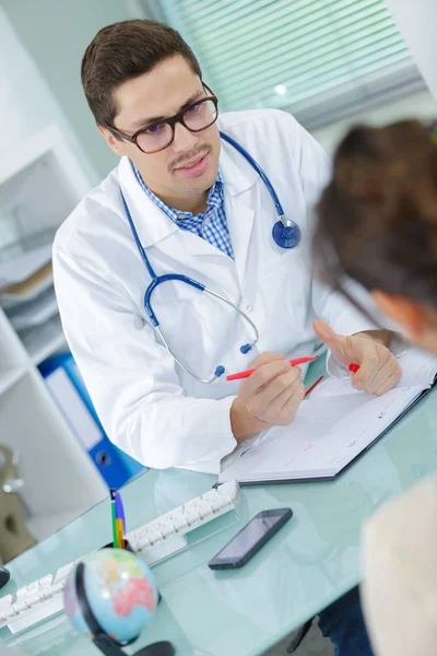 Médico prescrevendo droga para seu paciente em cirurgia brilhante — Fotografia de Stock