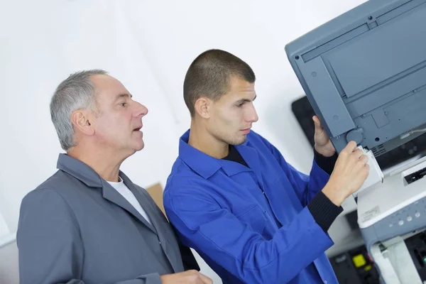 Lärling lagning en office-scanner — Stockfoto