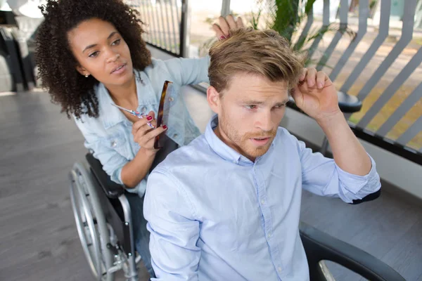 Beautiful disabled hairdresser cutting handsome mans hair — Stock Photo, Image