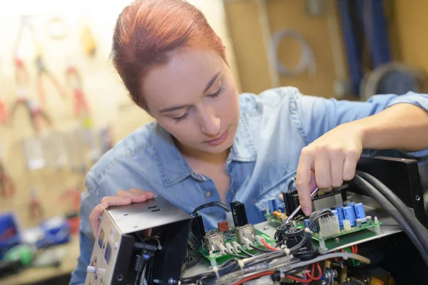 Koncentrerad kvinna reparera elektroniska enhet — Stockfoto