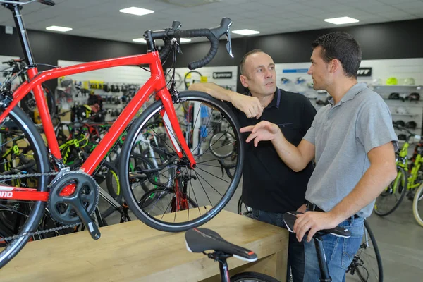 Hombre buscando bicicleta en tienda de bicicletas — Foto de Stock