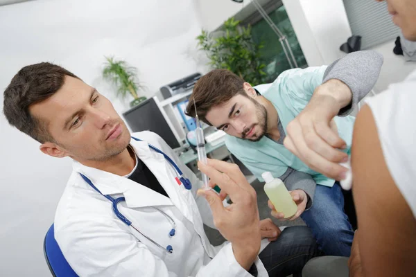 Médico y enfermera haciendo hombre lesionado tétanos toxoide inyección —  Fotos de Stock