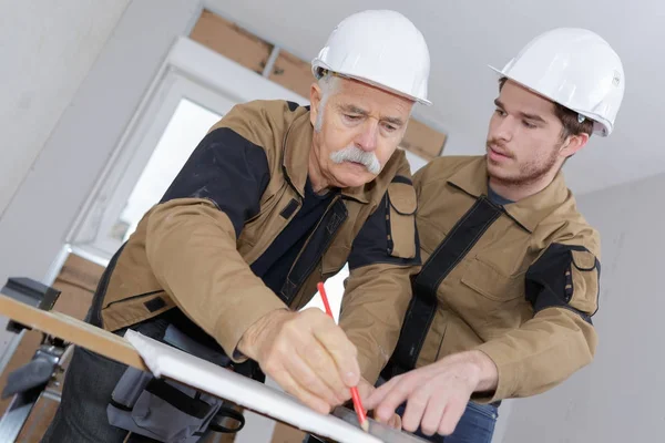 Senior-Handwerker zeichnet in Schreinerwerkstatt einen Plan — Stockfoto