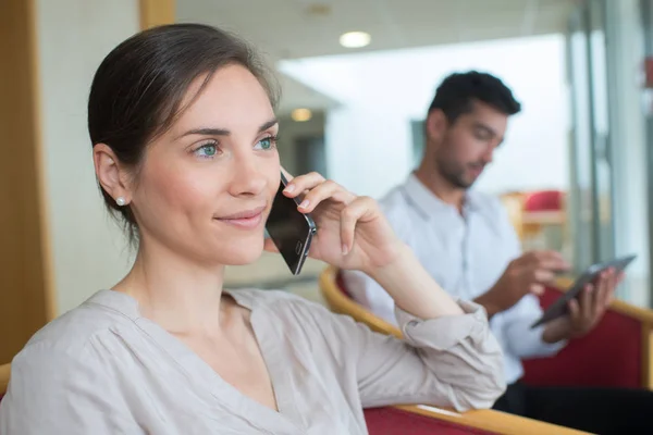 Beautiful young woman talking by telephone in office — Stock Photo, Image