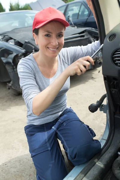 Mecánico femenino que fija una puerta de coche — Foto de Stock