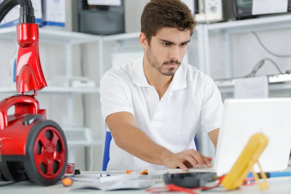 Ingeniero guapo investigando problemas de fabricación con la aspiradora —  Fotos de Stock