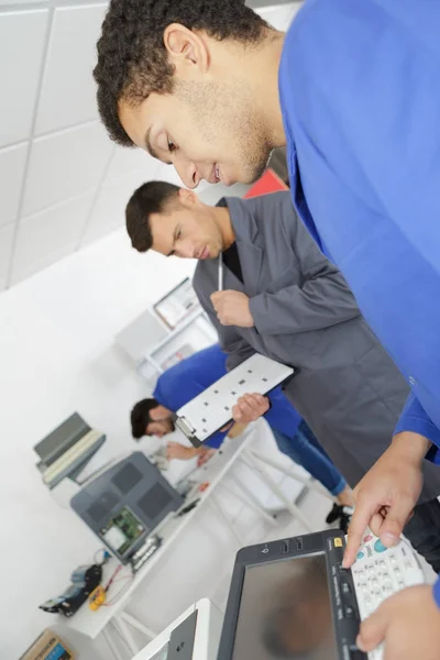 Jeune technicien masculin réparer photocopieuse numérique — Photo