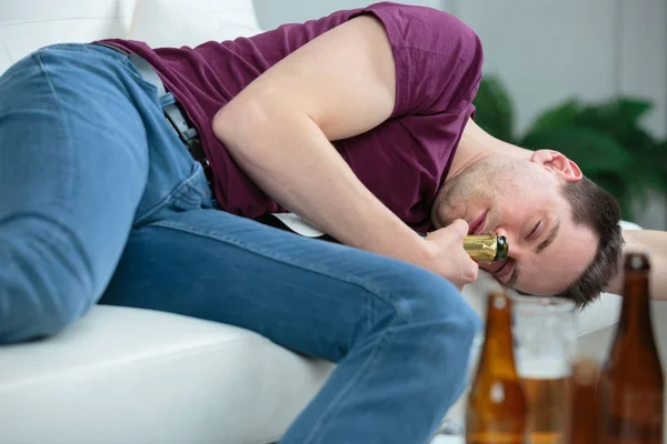 Uomo ubriaco che riposa a casa con una birra — Foto Stock