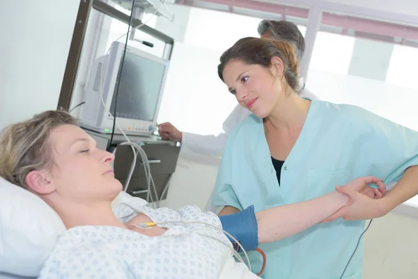 Mulher médico tomando pressão arterial de seu paciente — Fotografia de Stock