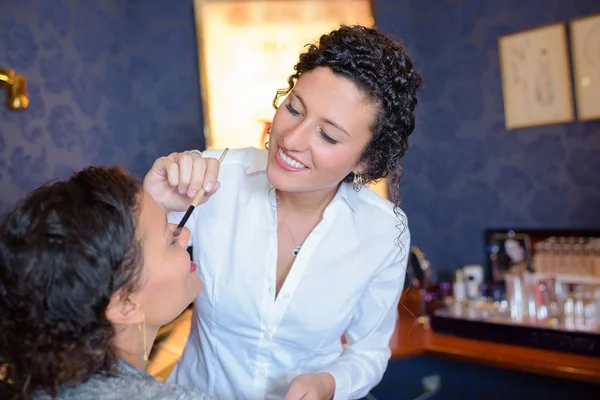 美容师将化妆品应用于客户 — 图库照片