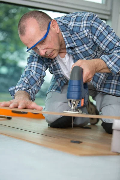 Hombre usando sierra para cortar madera —  Fotos de Stock