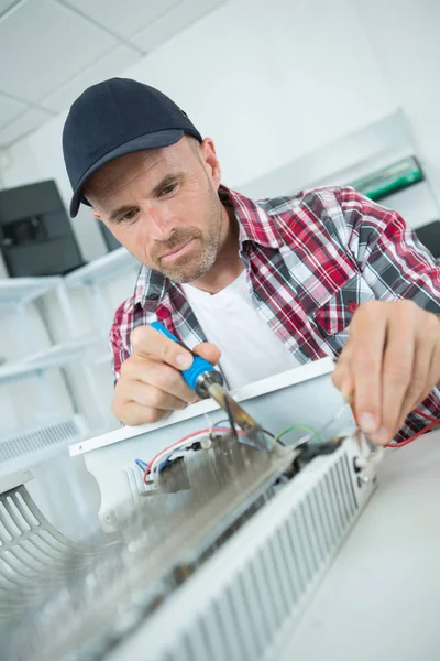 Trabalhador masculino ajustando a temperatura do aquecedor de água — Fotografia de Stock