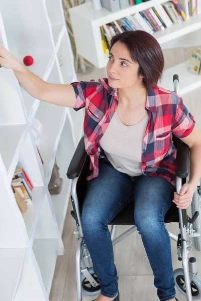 Kobieta siedzi na wózku inwalidzkim w domu — Zdjęcie stockowe