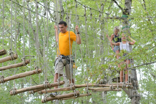 Bezoekers in avonturenpark op touwbrug — Stockfoto
