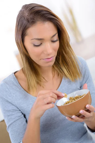 Jovem mulher comer cereais flocos de musselina — Fotografia de Stock