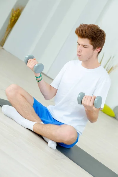 Jonge man oefenen met halters — Stockfoto