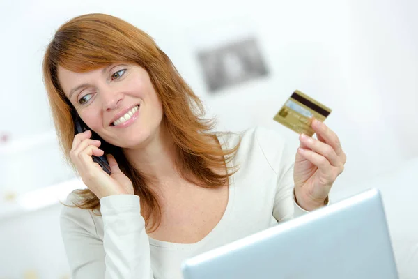 Schöne Frau mit Kreditkarte und Laptop auf der Couch — Stockfoto