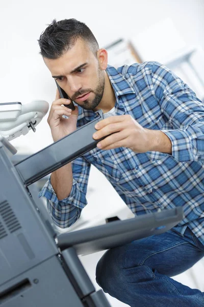 Hombre inspeccionando la máquina de impresión —  Fotos de Stock