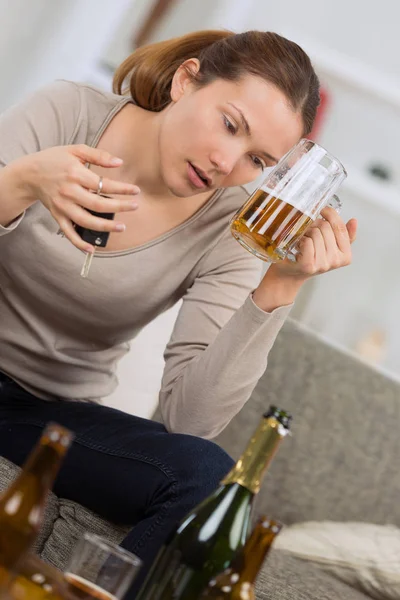 Ung kvinna som håller både bilnycklar och pint öl — Stockfoto