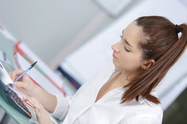 Ung kvinna student gör hennes läxor — Stockfoto