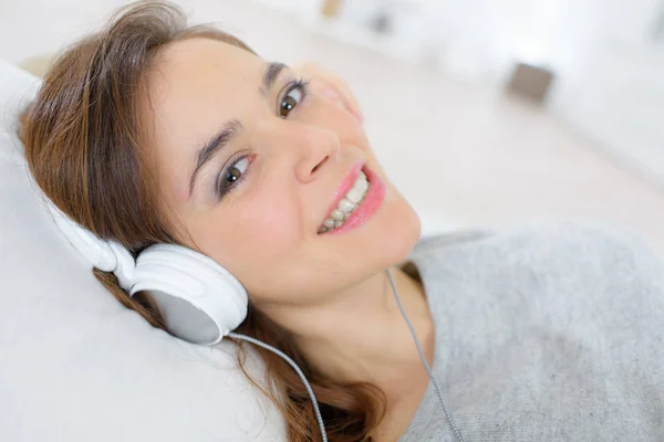 Feliz sorrindo menina bonita ouvir música através de fones de ouvido — Fotografia de Stock