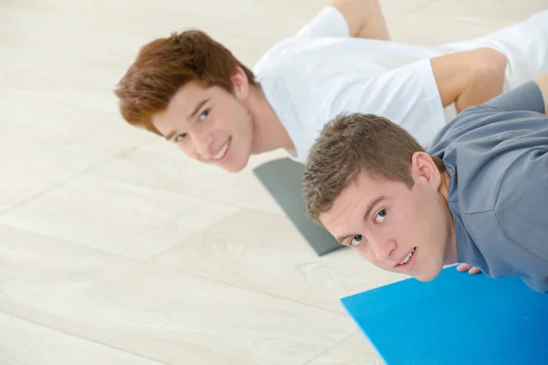 Två unga män i gym tränar — Stockfoto