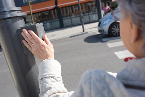 Ouderen voetgangers dringende knop aan de straat oversteken — Stockfoto