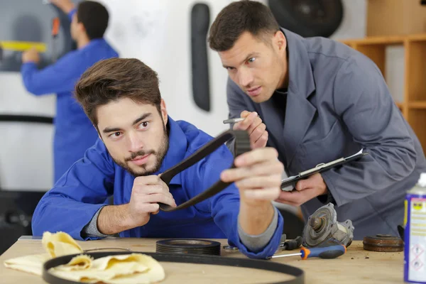 Insegnante e apprendista meccanico con cinture in pelle — Foto Stock