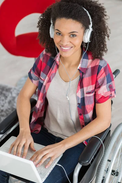 Confident disabled woman using laptop at desk in creative office — Stock Photo, Image