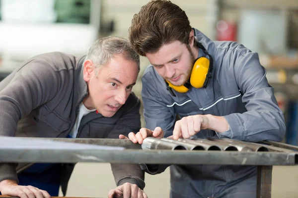 Lavoratori con paraorecchie e apprendista — Foto Stock