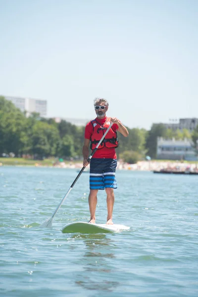 Paddleboard와 호수에 타고 즐기는 남자 — 스톡 사진