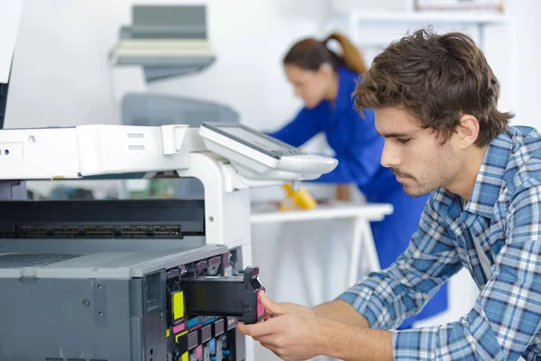 Reparatur des Druckers durch einen jungen Techniker — Stockfoto