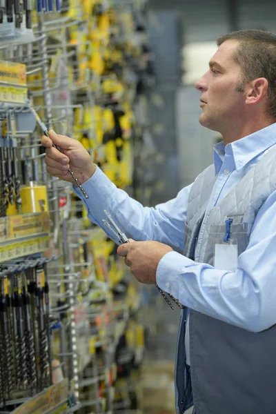 Cliente masculino compra ferramentas de trabalho no supermercado — Fotografia de Stock